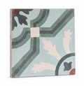A square decorative ceramic tile with a vintage-style geometric and botanical pattern in muted green, dusty pink, charcoal, and terracotta on a pale blue-gray background, shown on a clean white studio background.