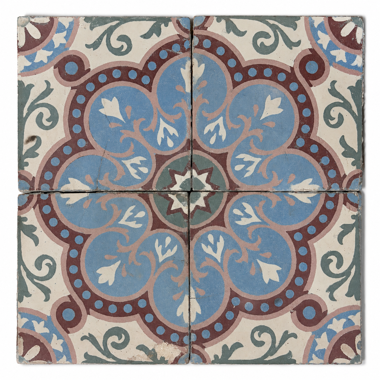 Four antique French cement tiles forming a blue, burgundy, blush, and green floral medallion.