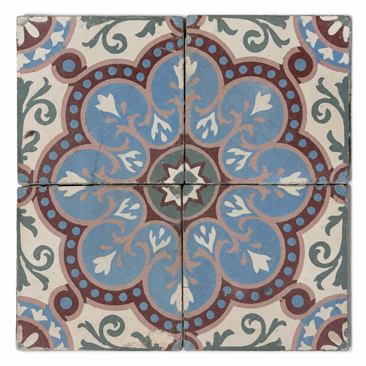 Four antique French cement tiles forming a blue, burgundy, blush, and green floral medallion.